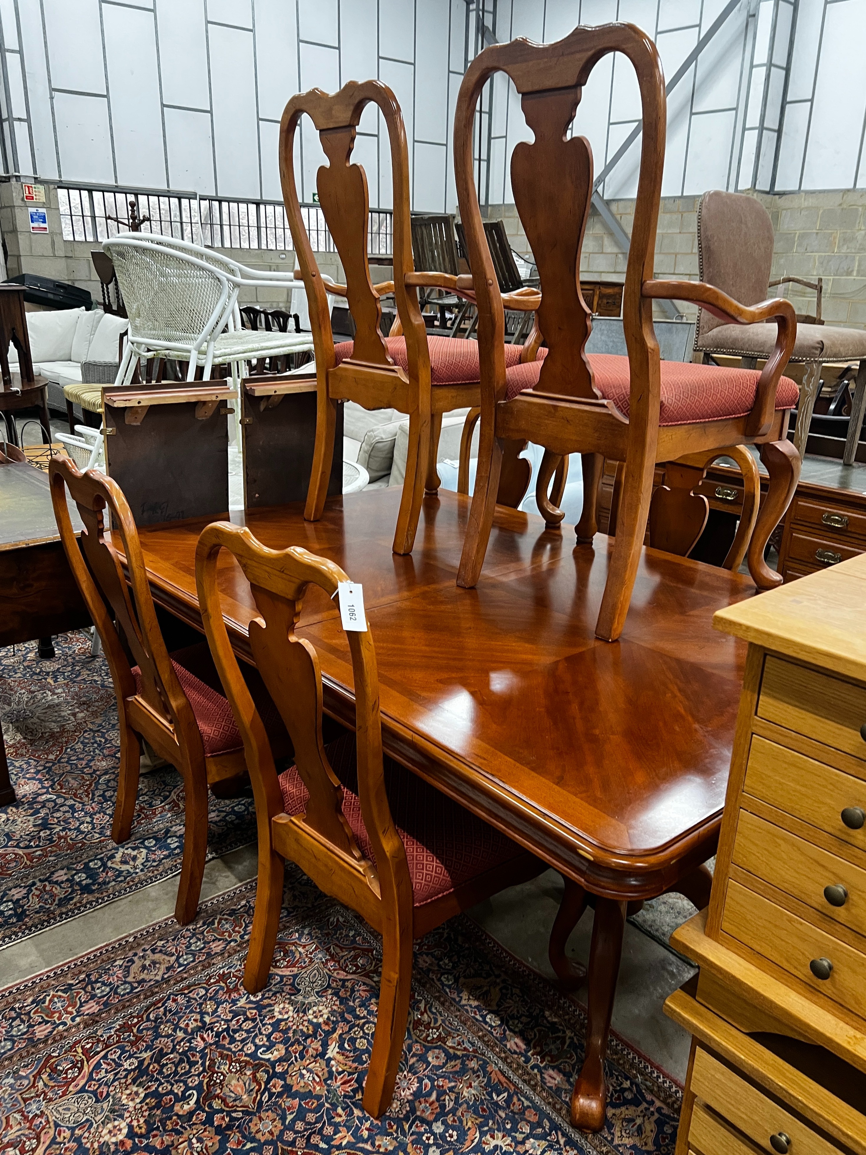 A reproduction Queen Anne style banded cherry twin pillar extending dining table, length 240cm extended (two spare leaves), depth 110cm, height 75cm and six chairs, two with arms